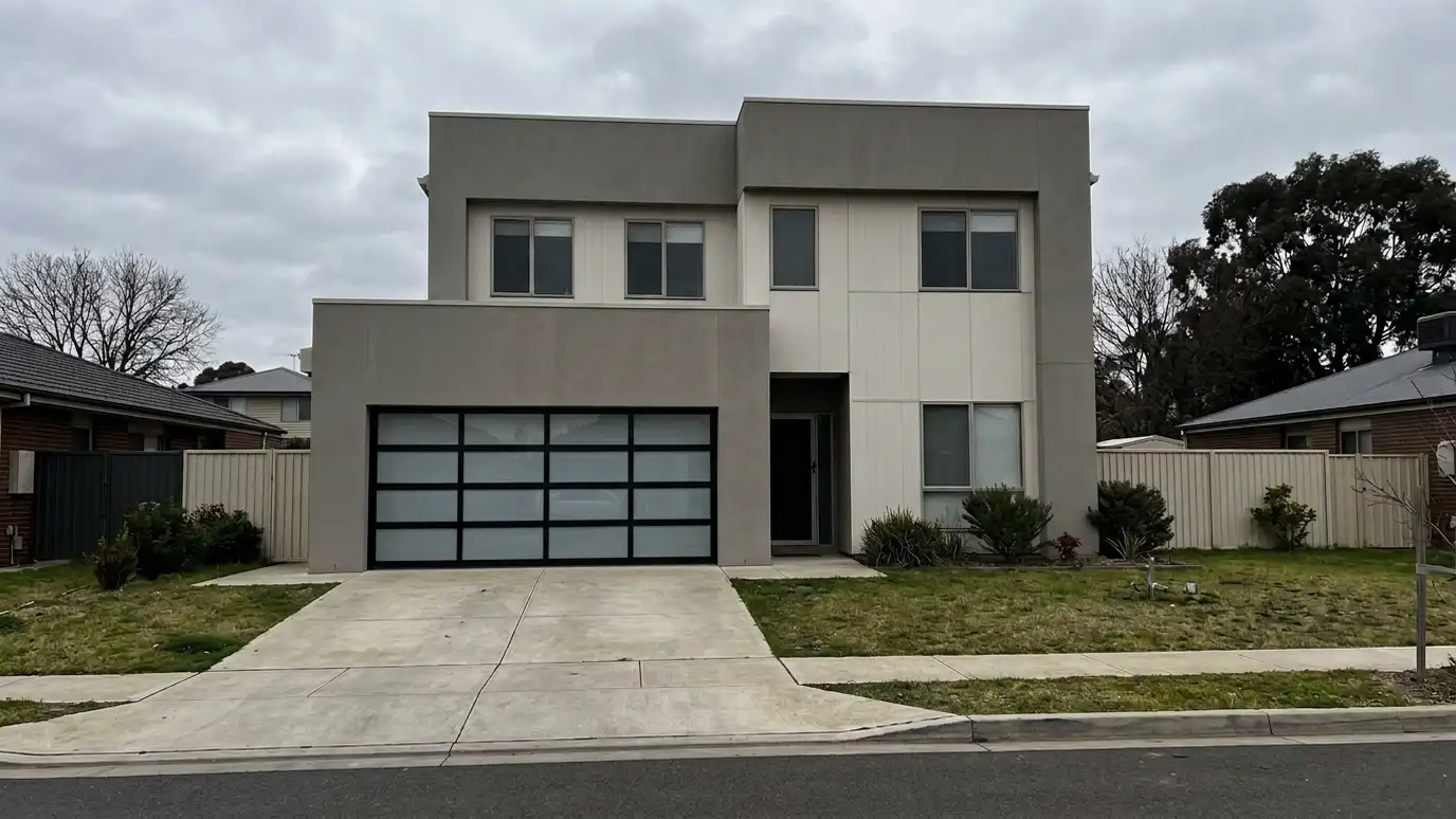 After: A plain door replaced by a modern full-view door | Music City Garage Door Service After: a modern home with a black-framed full-view aluminum and frosted glass door